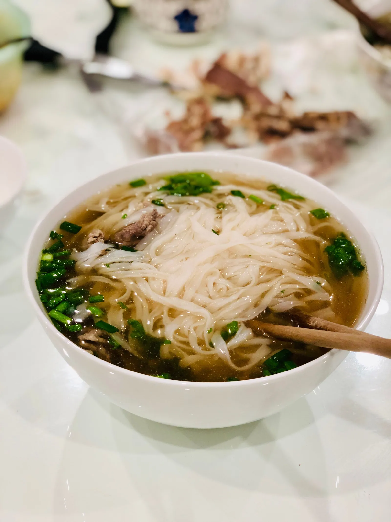 A bowl of Vietnamese pho with beef and greens