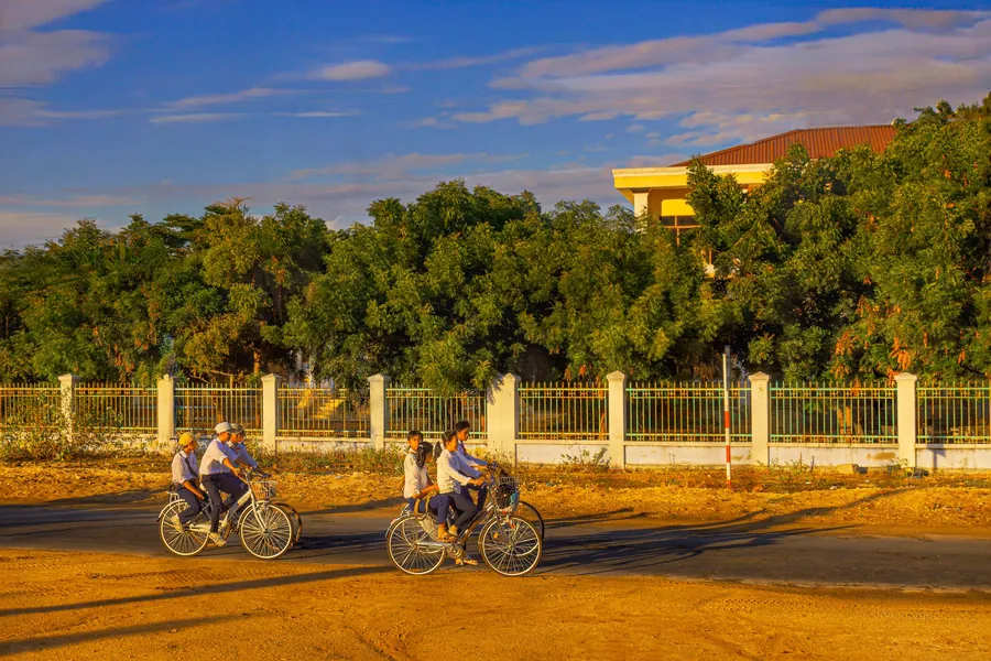 Children cycling outdoors in Vietnam in warm evening light