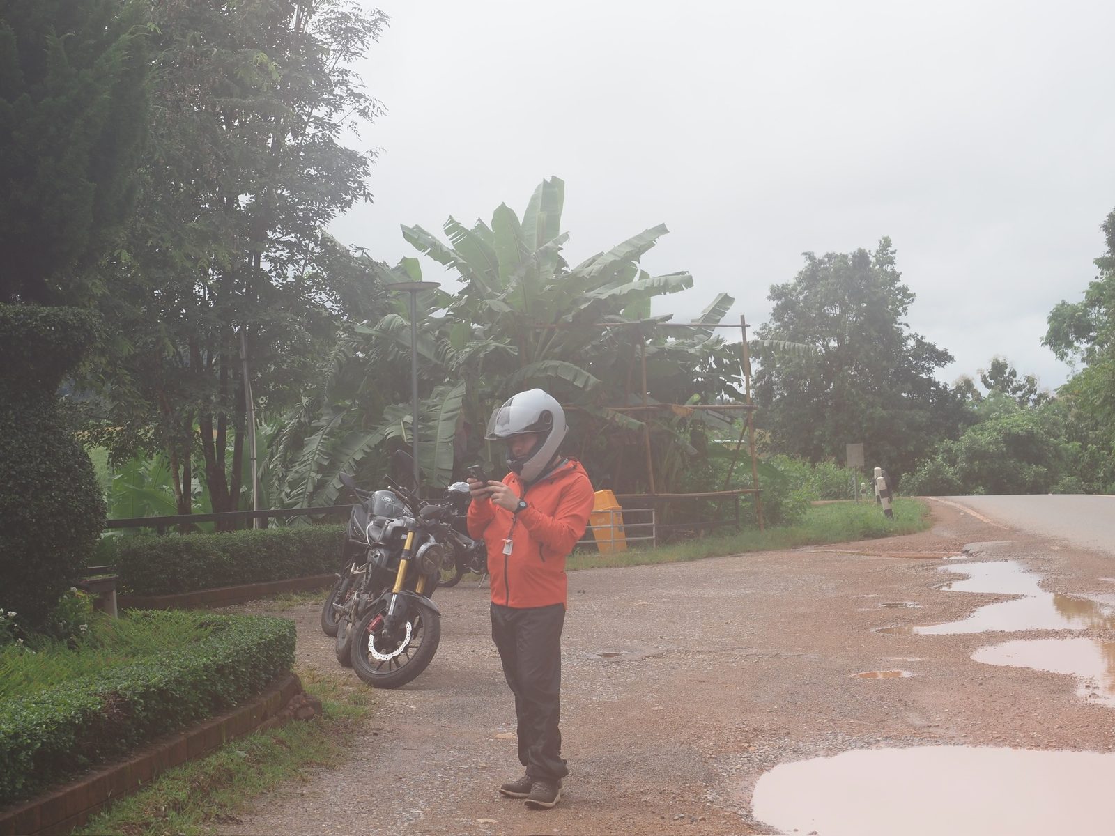 Rider with motorbike stopped on a wet road near Mae Hong Son